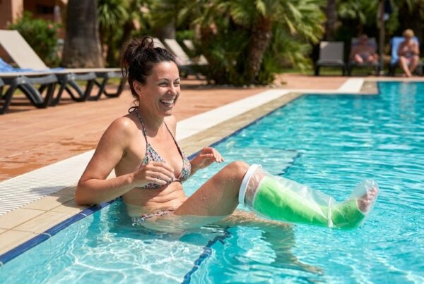 Woman in a pool wearing a leg cast cover